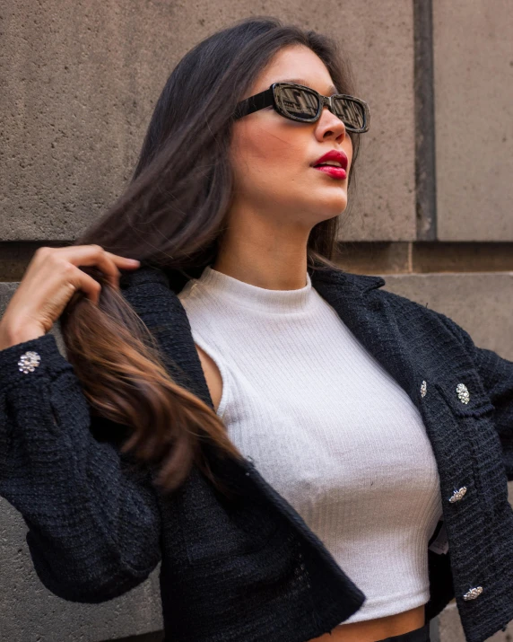 a woman with sunglasses on her face holding her hair