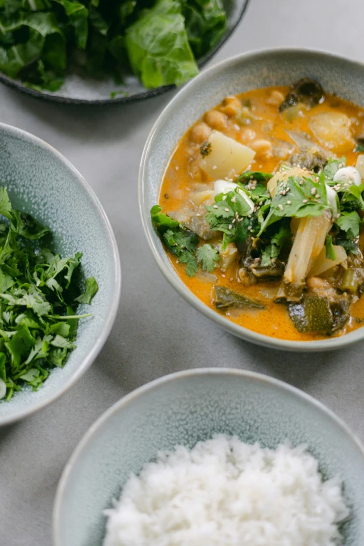 four bowls of food that include rice, spinach, and broccoli