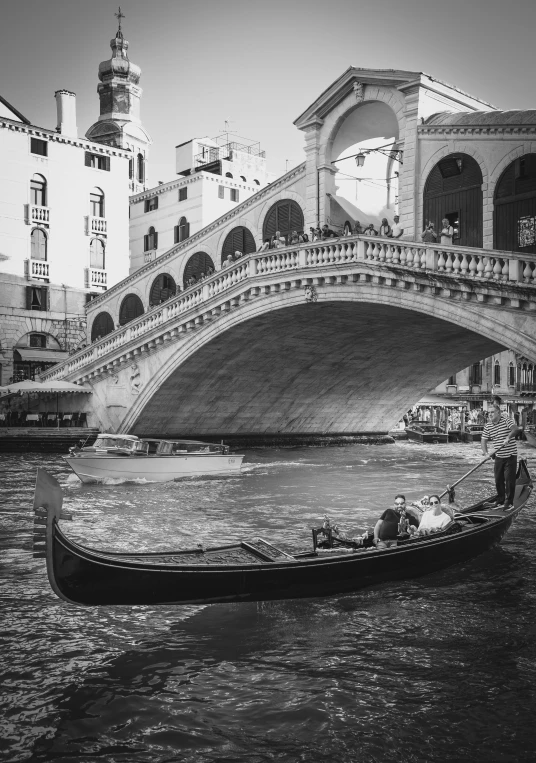 a boat traveling along a river under a bridge