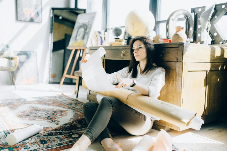 a woman sitting on the ground in her room