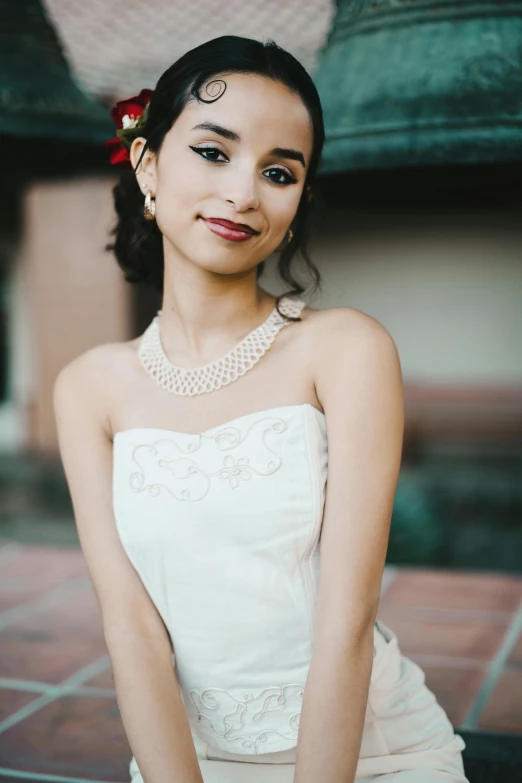 an asian woman wearing a white dress sitting down