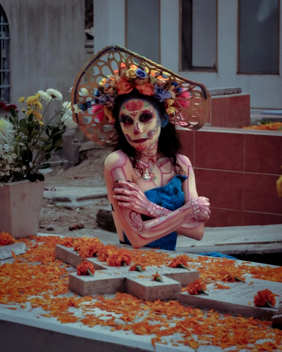 a woman with makeup in a costume standing behind flowers