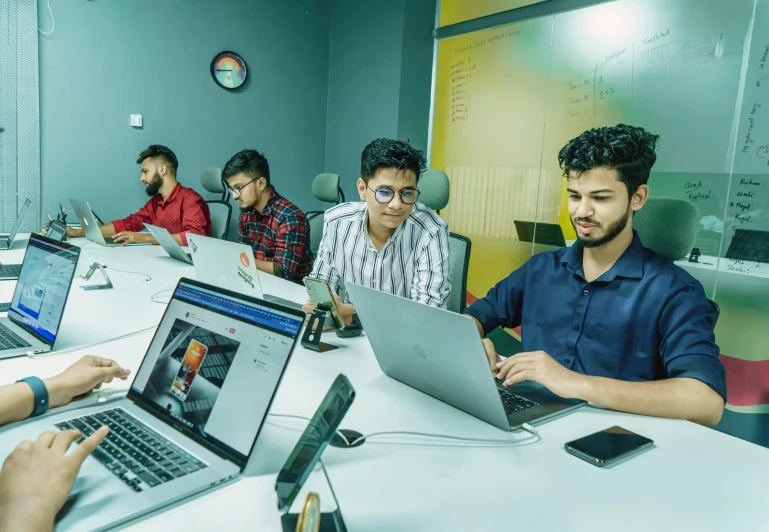 people sitting at tables working on computers