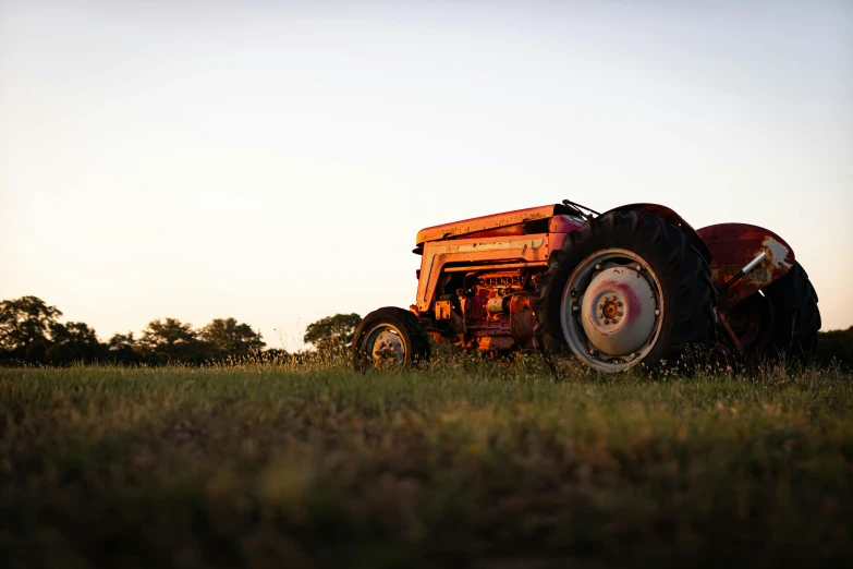 a tractor parked in a field at sunrise