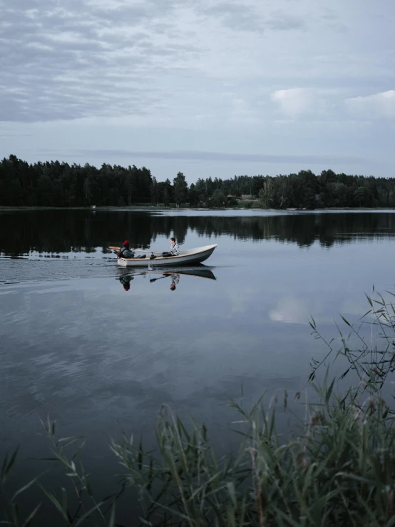 two boats are in the water near trees