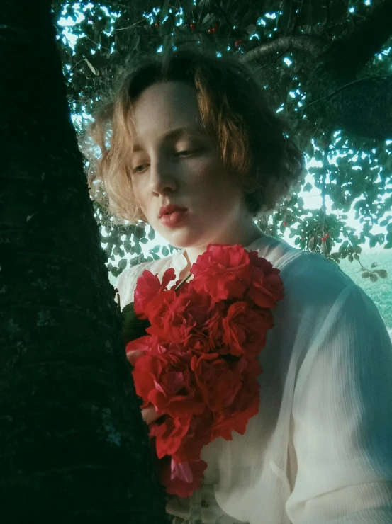 the woman is hiding behind the tree near the flowers