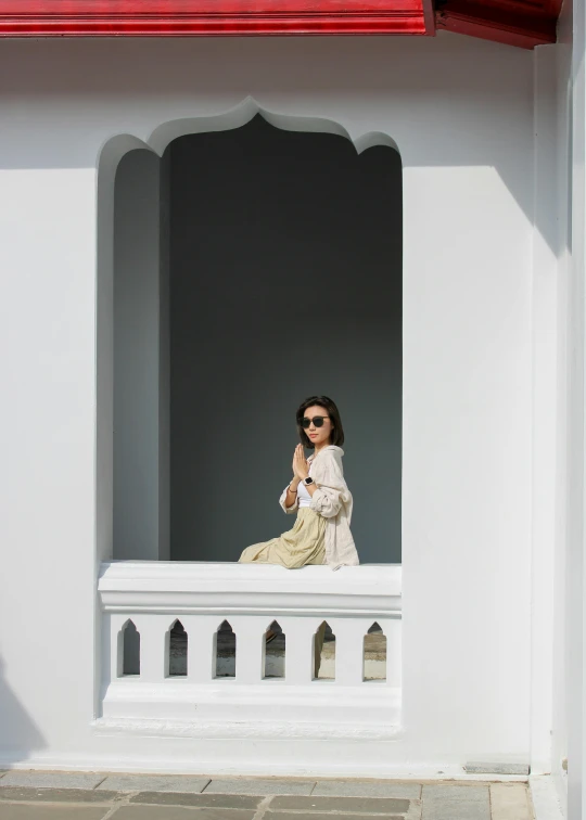 woman sitting on ledge on tiled building outdoors