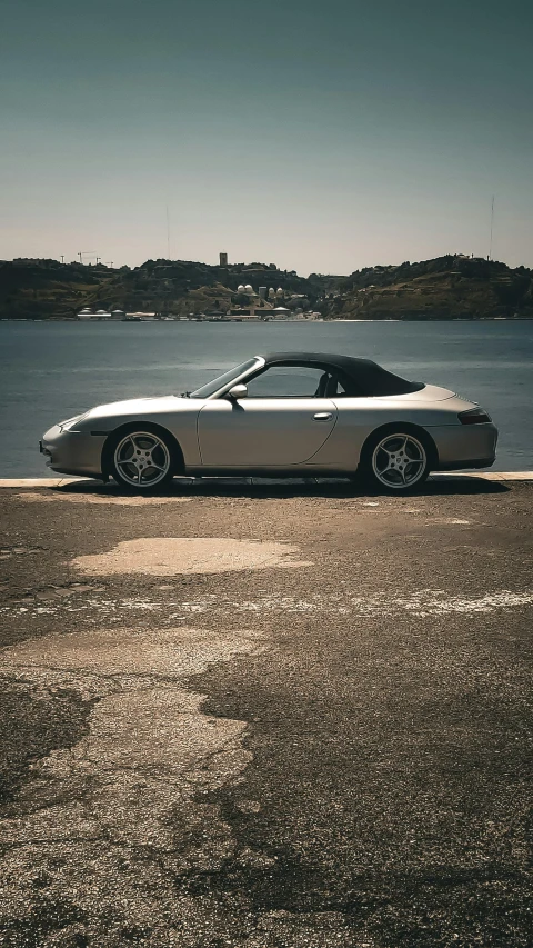 a car parked in front of the ocean on a sidewalk