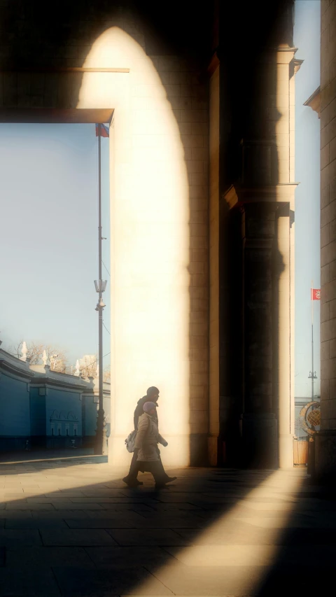 the shadow of someone walking next to a wall