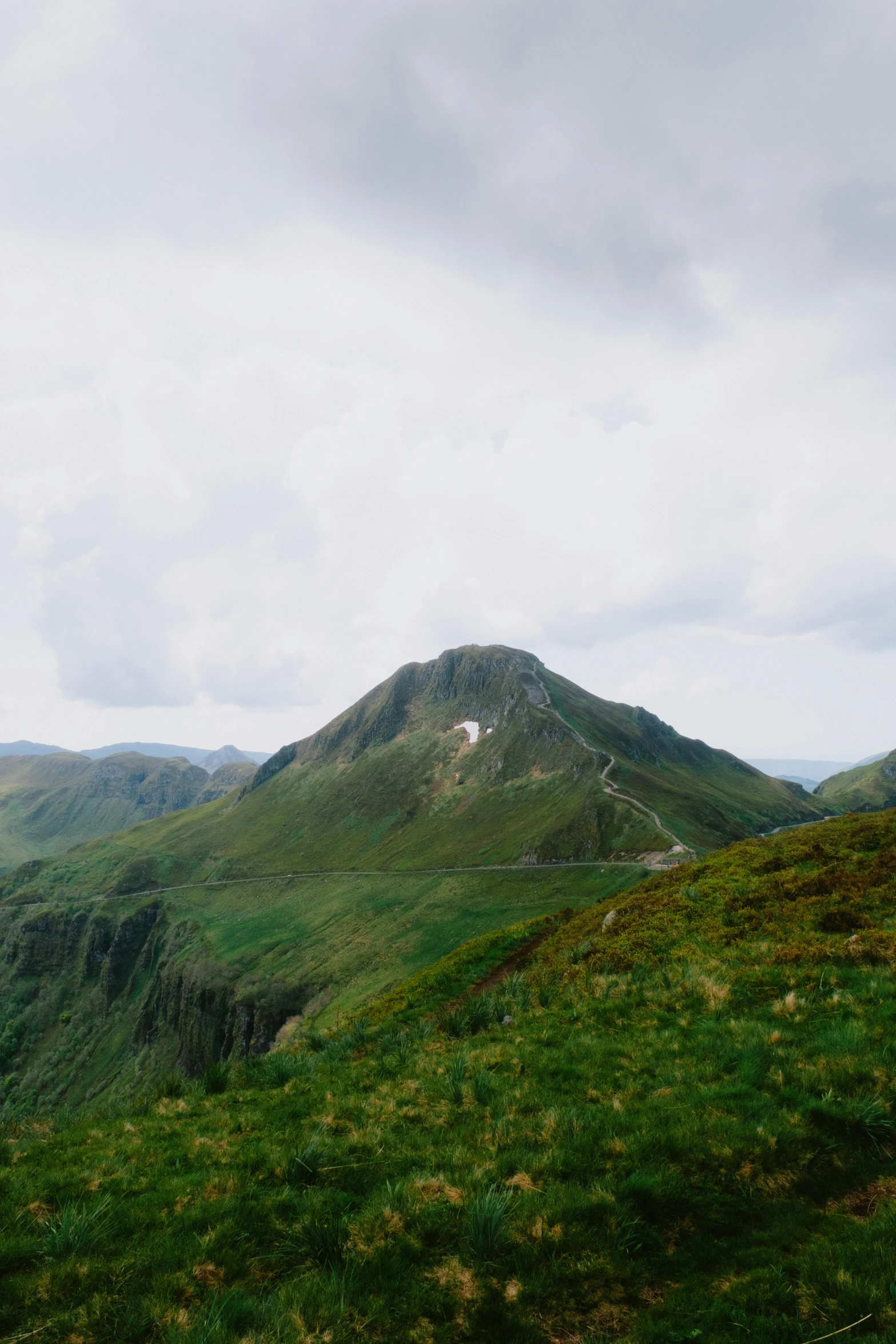 the mountains of a grassy plain with grass growing on each side