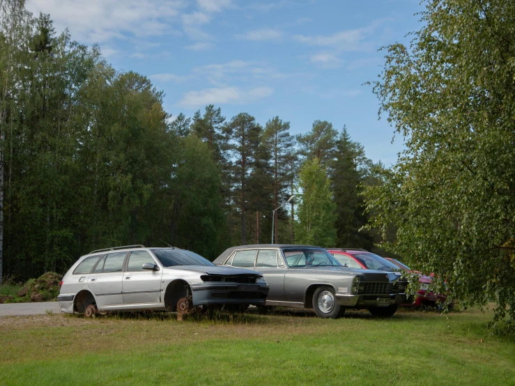 two cars are parked in the grass on a street corner