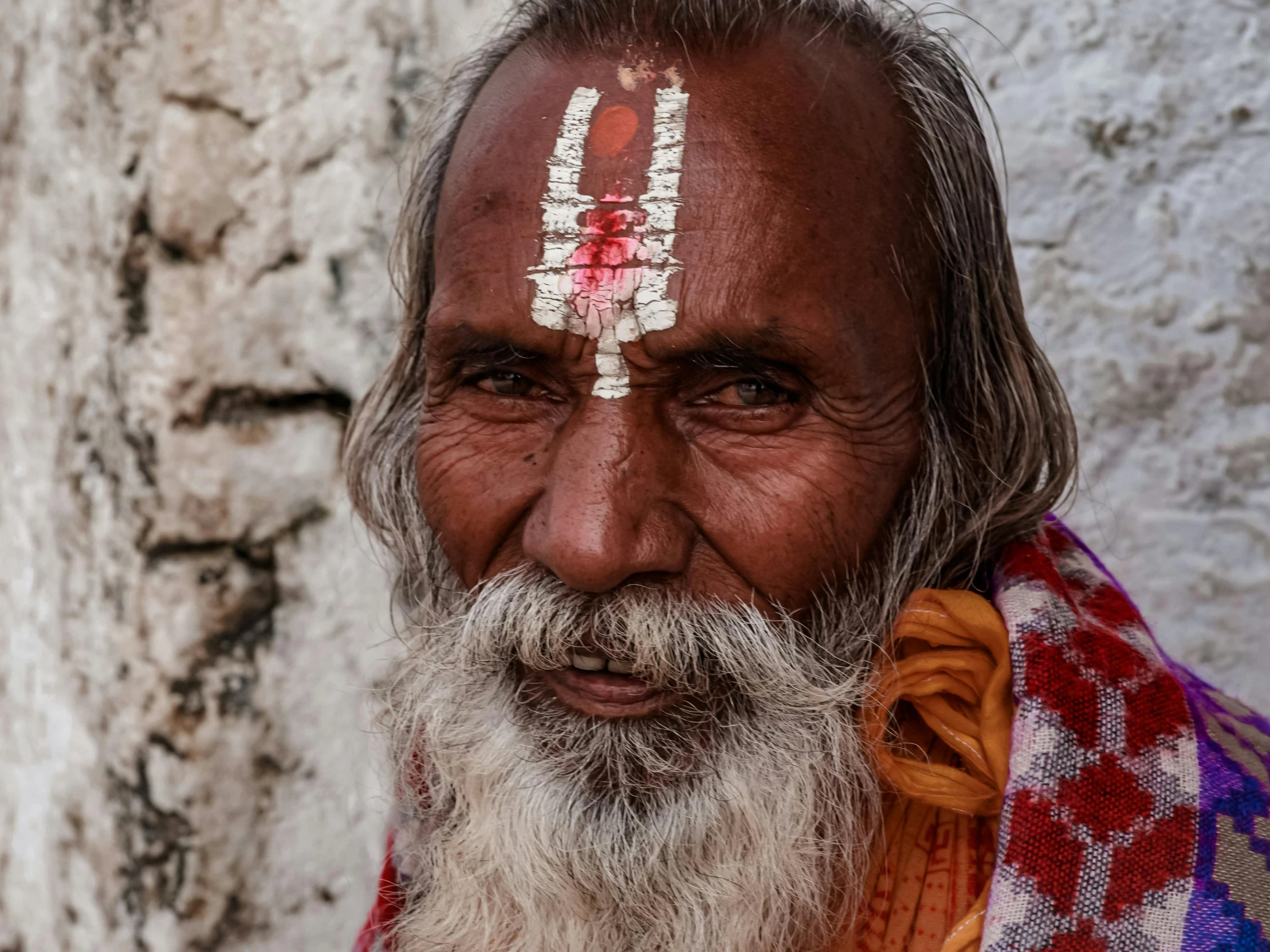 an indian man in front of a stone wall