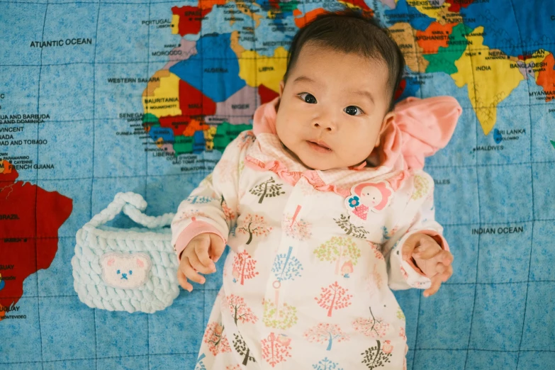 a young child poses for a picture in front of the map