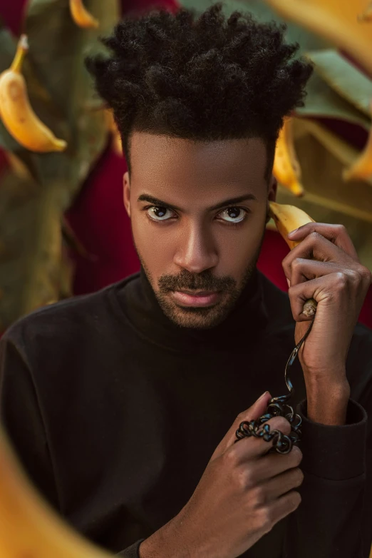 an african american man in black shirt holding bananas