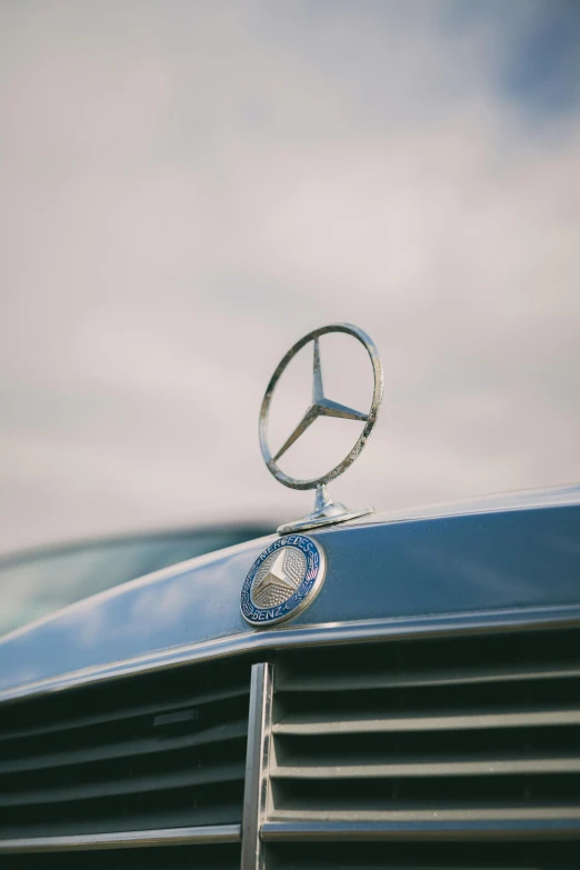 mercedes badge is seen on the front of an old car