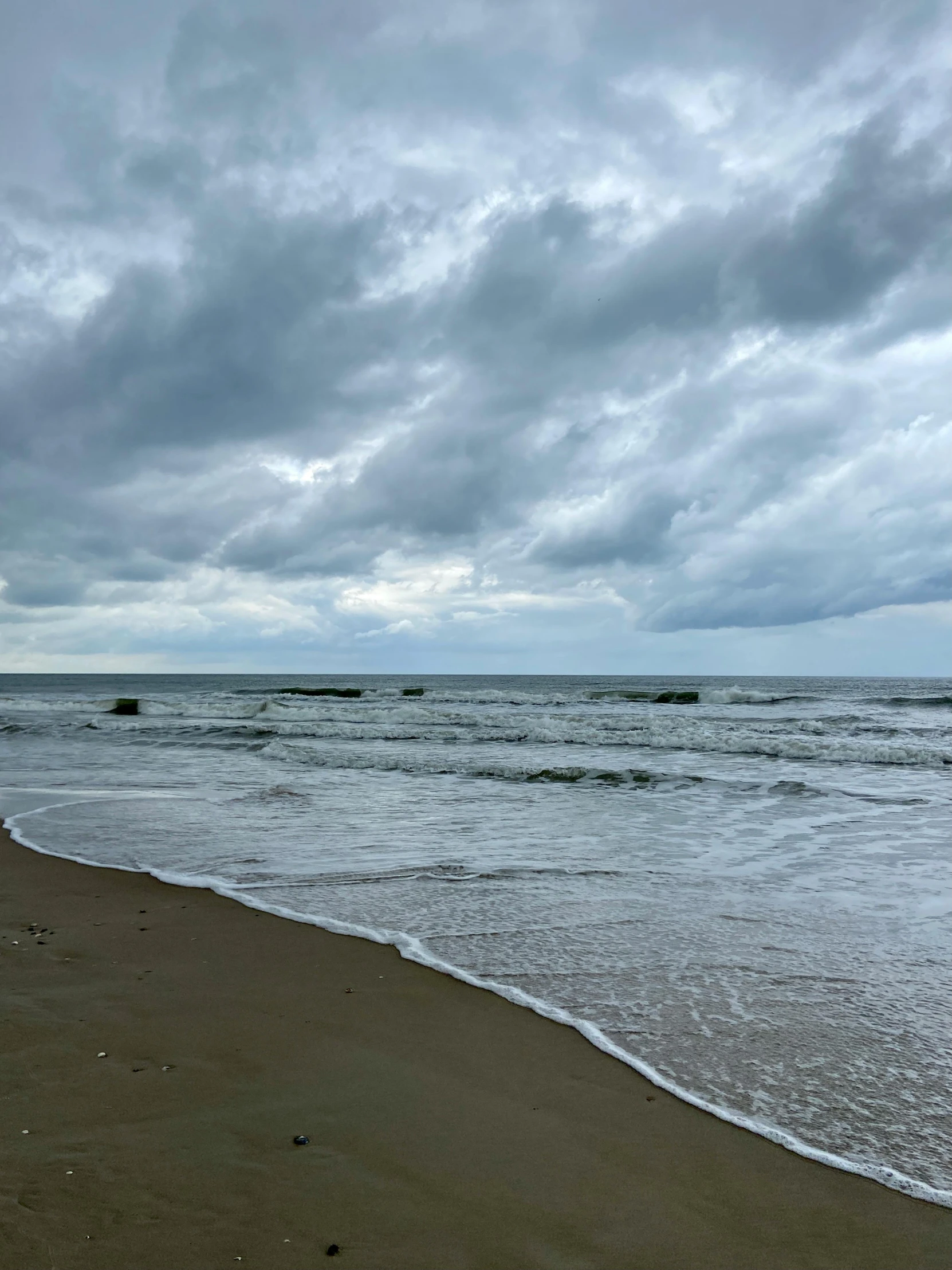 a lonely beach area under a cloudy sky