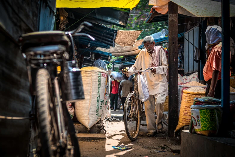 a man with a bicycle outside a shop