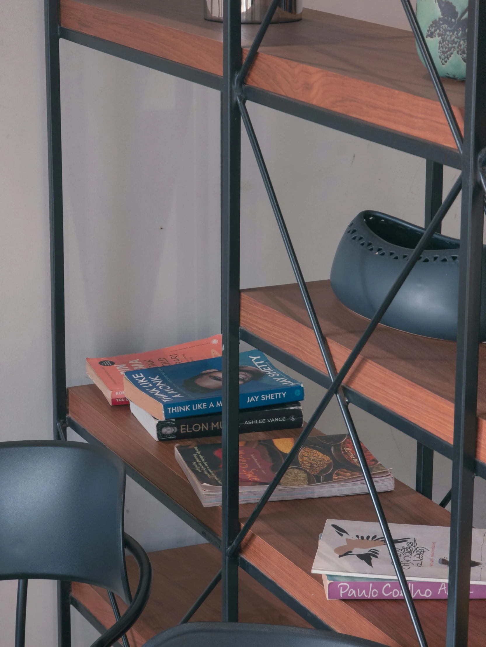 a shelf with books and plant on it