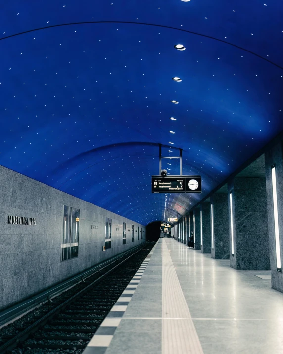 a train station has a blue ceiling and stars on the ceiling