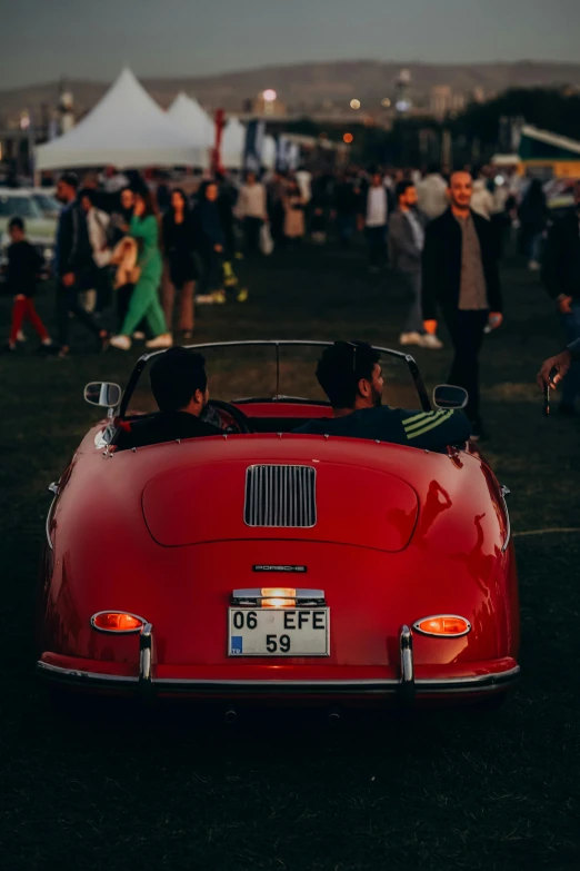 a group of people gathered outside looking at cars