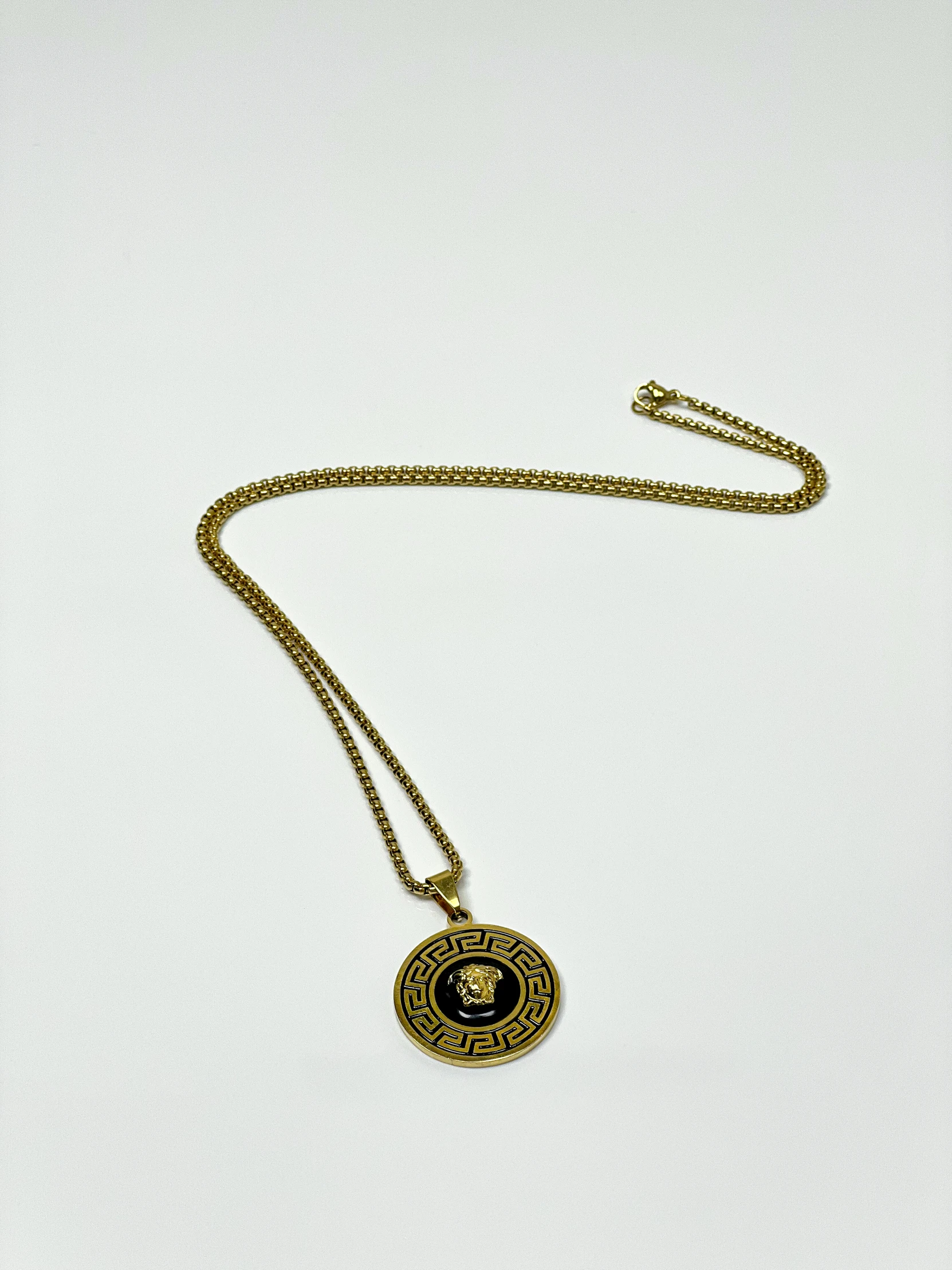 a necklace with an evil eye hanging on a long gold chain