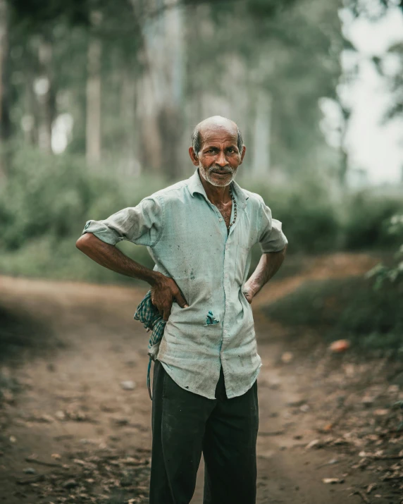 a person standing on a dirt road in the woods