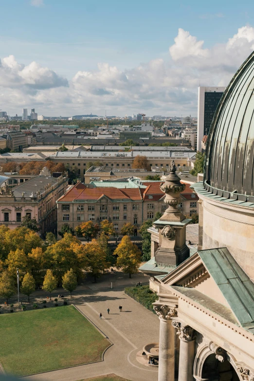 a panorama image of a city with buildings, trees, and green roofs