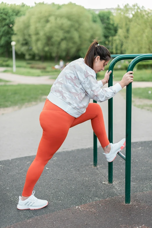 a woman standing on one leg next to a bench