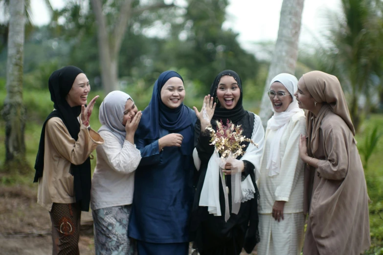 six women in hijab are standing together smiling