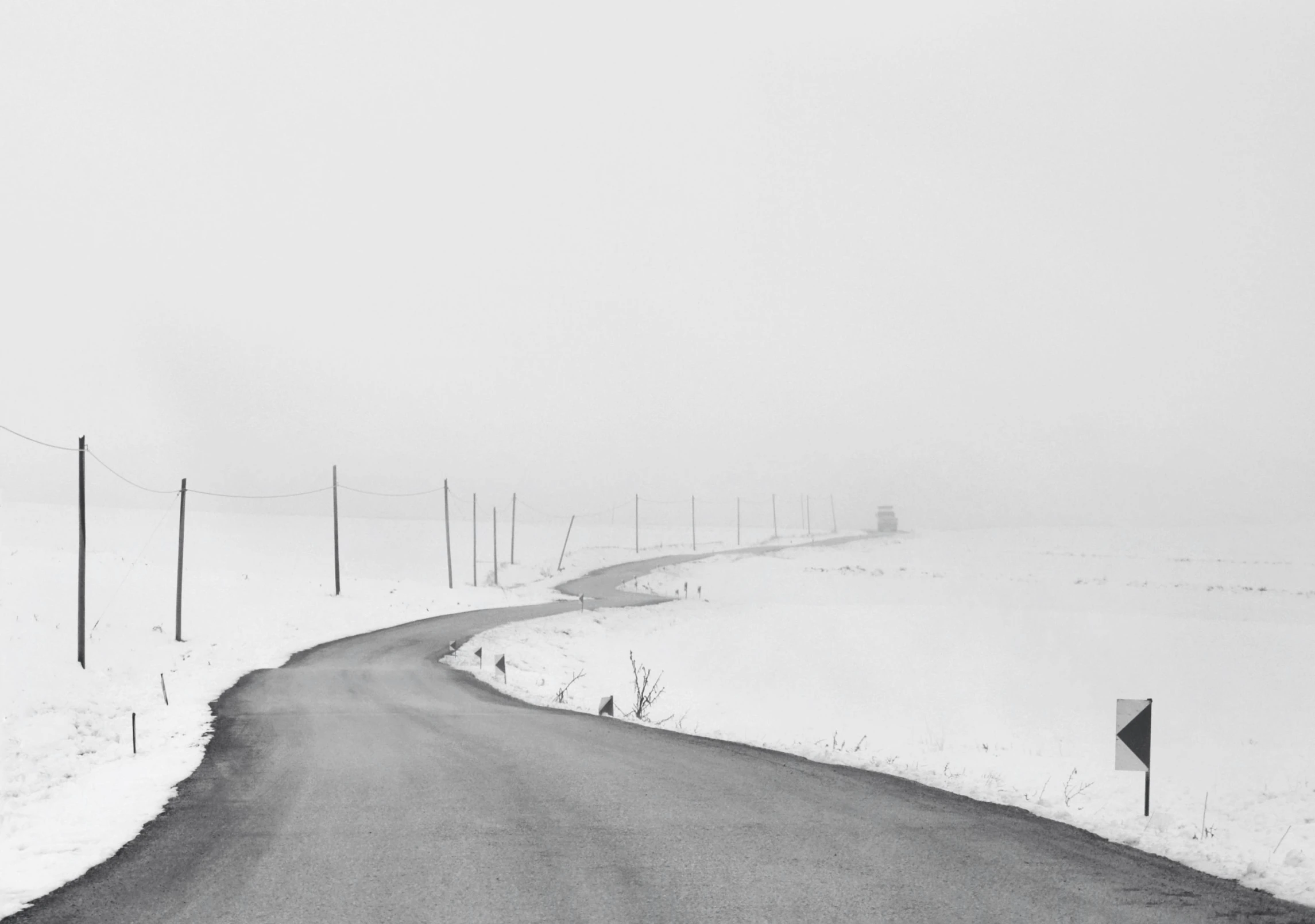 the road is empty on the snowy mountain side