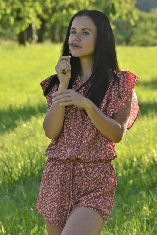 a woman is posing in the grass