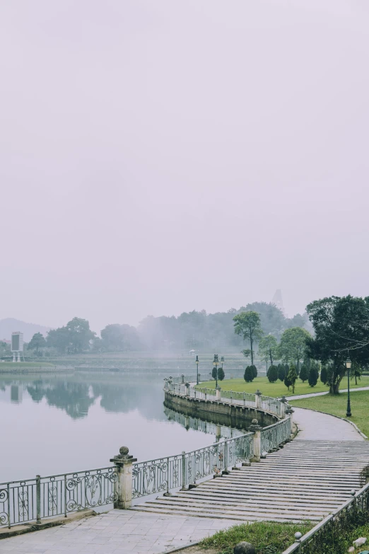 a lake and a walkway with benches on each side