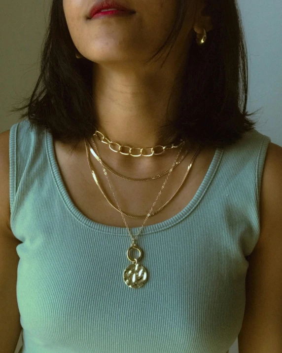 a young woman wearing two necklaces with circles on them