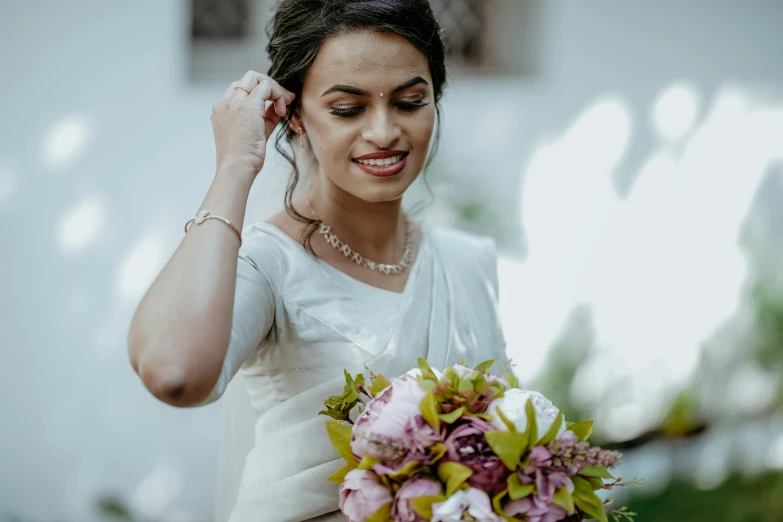 a bride holds her wedding bouquet of pink flowers