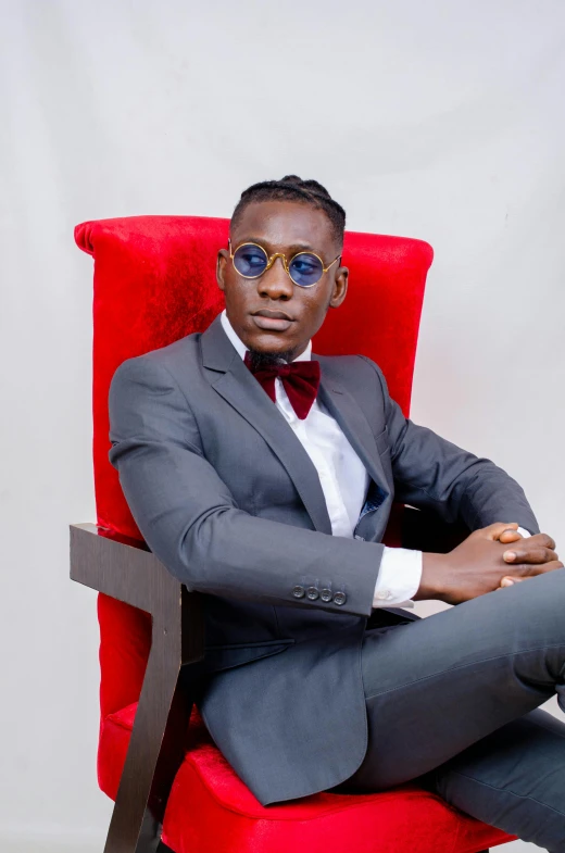 an african american man wearing sunglasses is sitting in a chair with his arms crossed