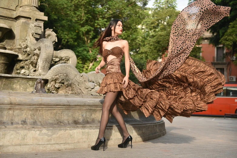 a lady in a brown dress holding an umbrella