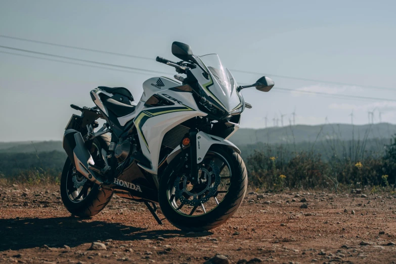 a white and yellow motorcycle parked in front of a forest