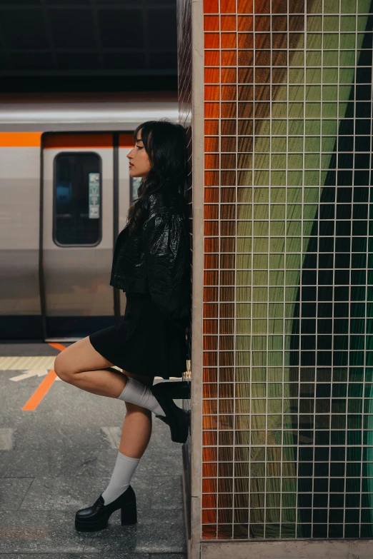 there is a young woman that is sitting on the edge of a train station