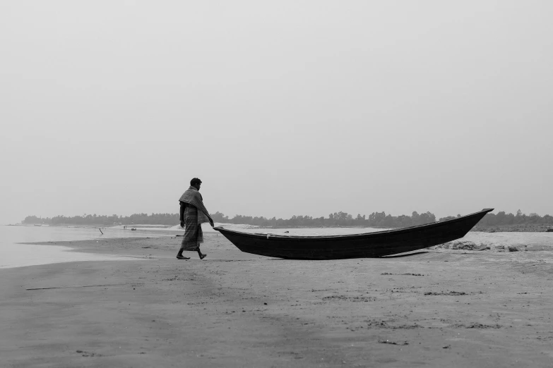 a man is walking next to a long boat