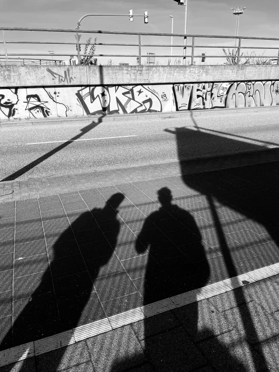 two people walk next to each other near a wall