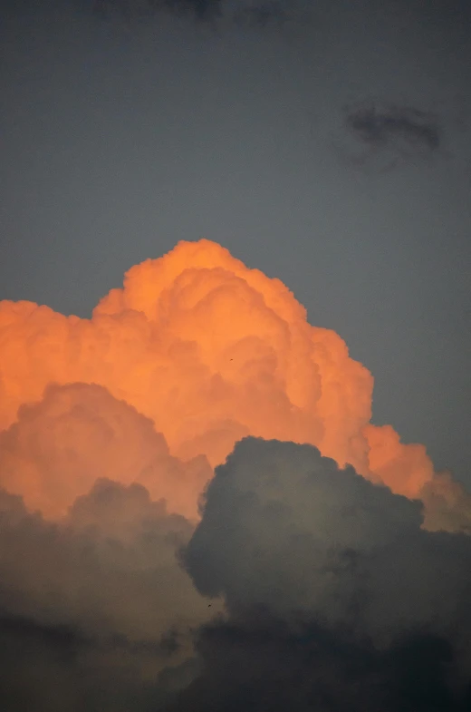 there are clouds lit up orange and dark