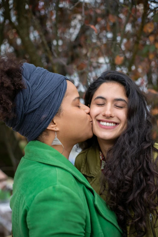 a couple of girls are kissing and posing