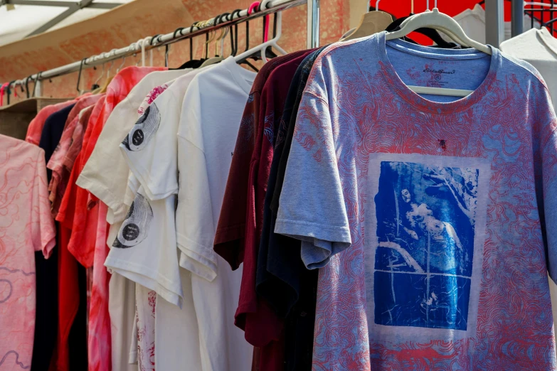 a rack with different colored shirts hanging on it