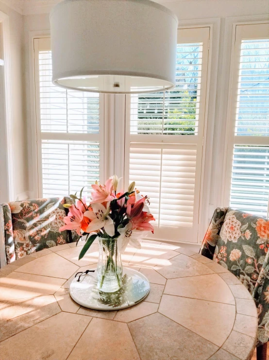 the vase with flowers is sitting on a table