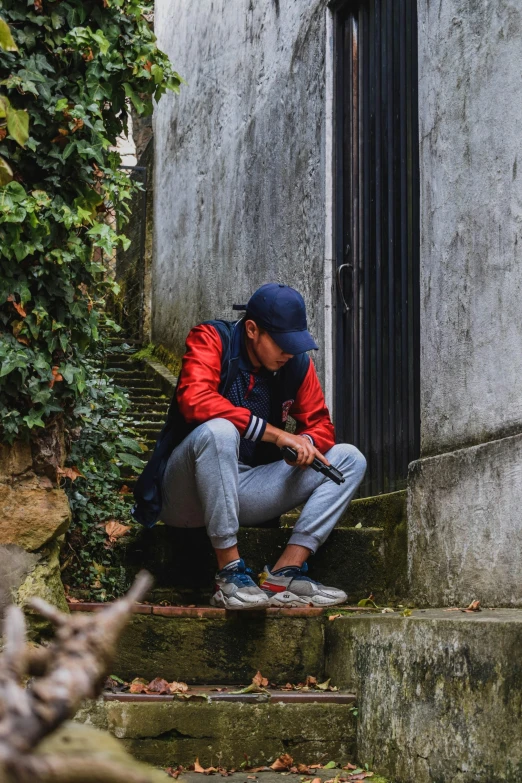 a young person sitting on some steps with a glove