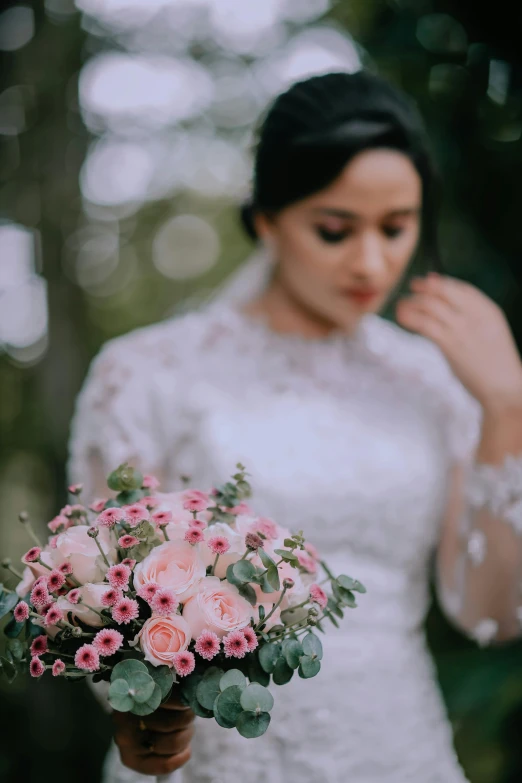 a woman holding a wedding bouquet in her hand