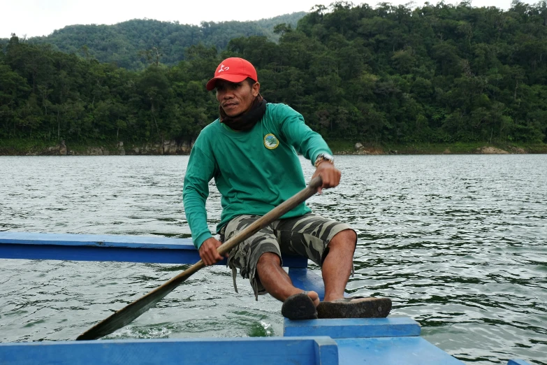 a man on a boat sitting on a paddle