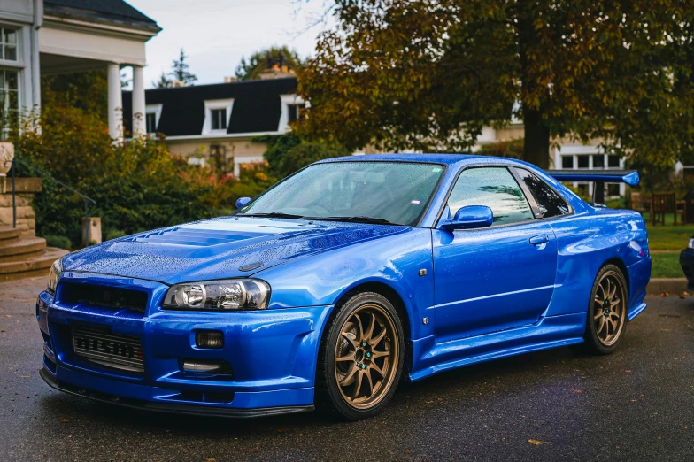 a bright blue car is parked in a driveway