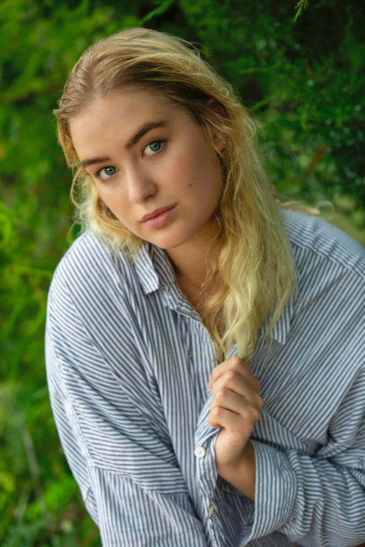 a girl in a striped shirt is posing