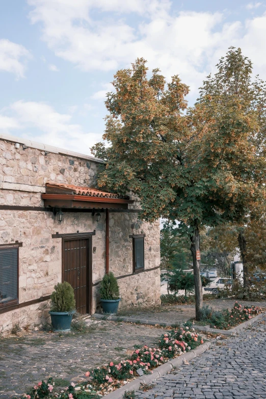 a brick building with trees and potted plants next to it